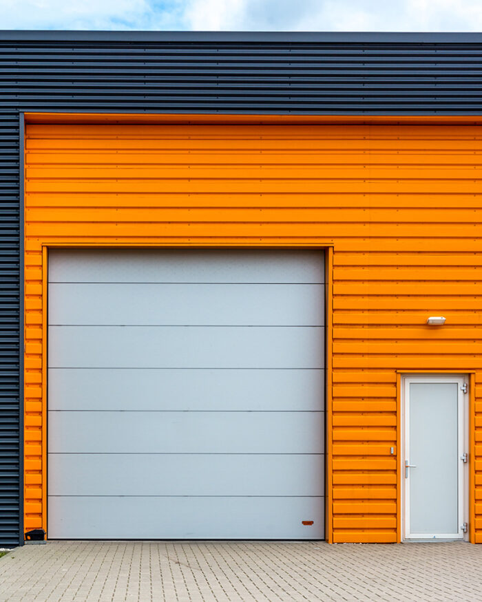 custom roller shutter door on an orange warehouse installed by MV Roller shutter doors